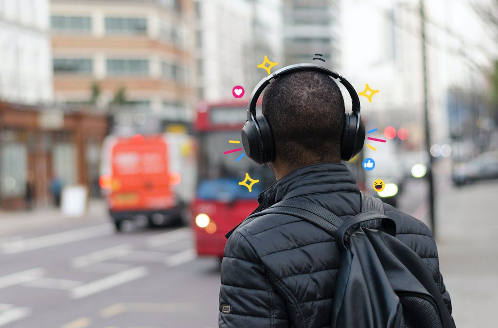 A man waiting for a bus in London wearing headphones